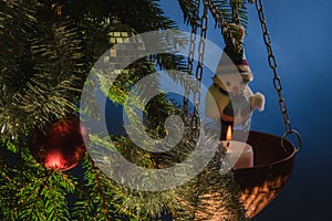 Snowman and other ÃÂ¡hristmas decorations on fir tree with a lit candle photo